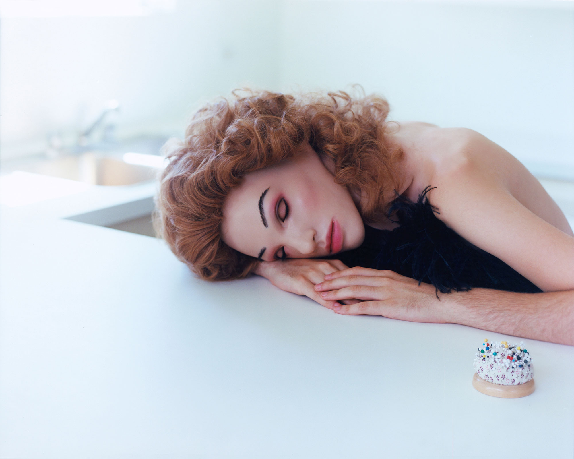 person's head resting on their hands on top of a table
