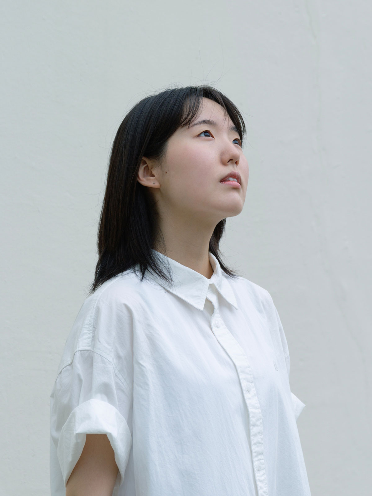person wearing white shirt looking at something out of frame