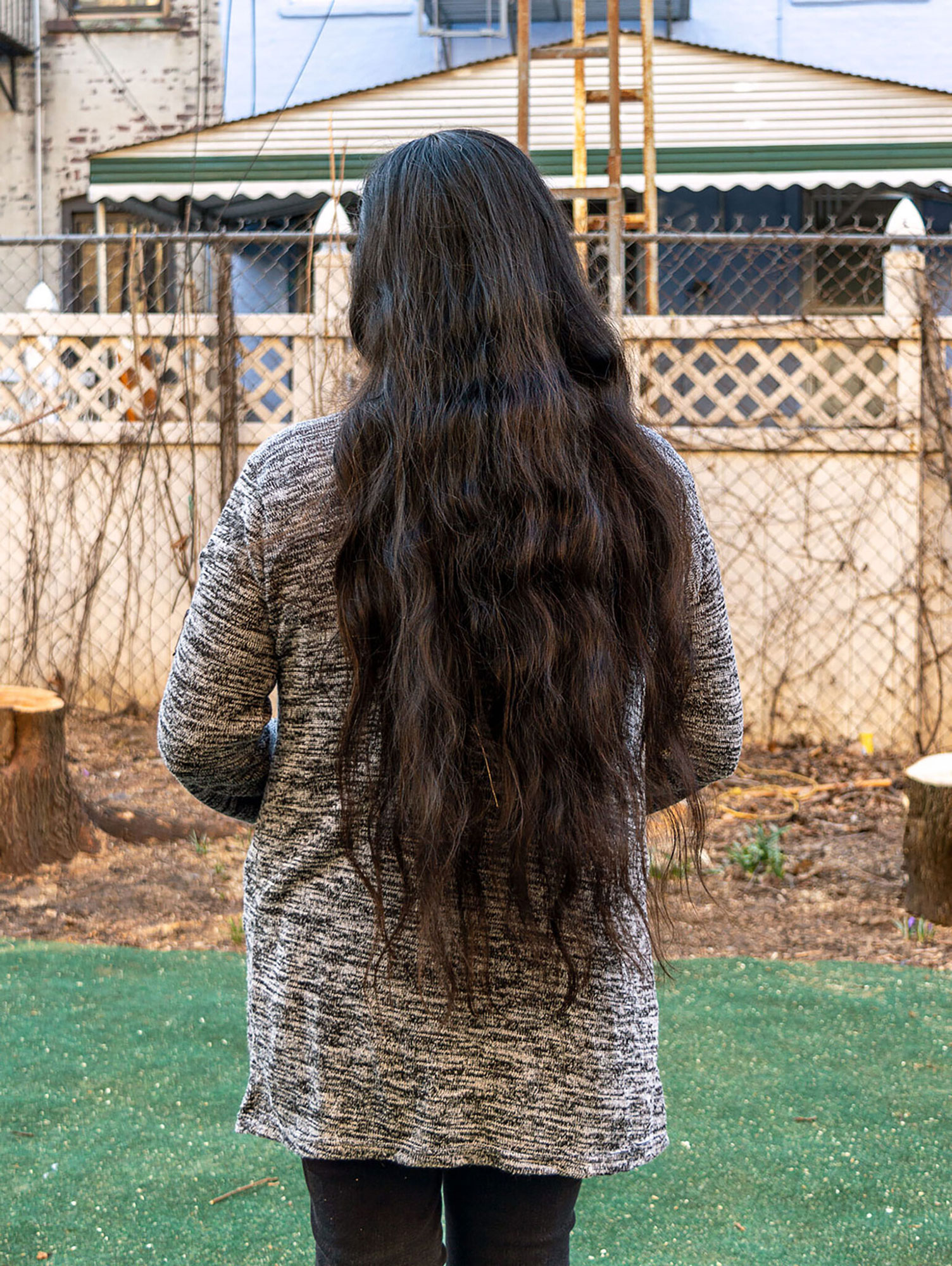 person with long brown hair, standing with their back to camera