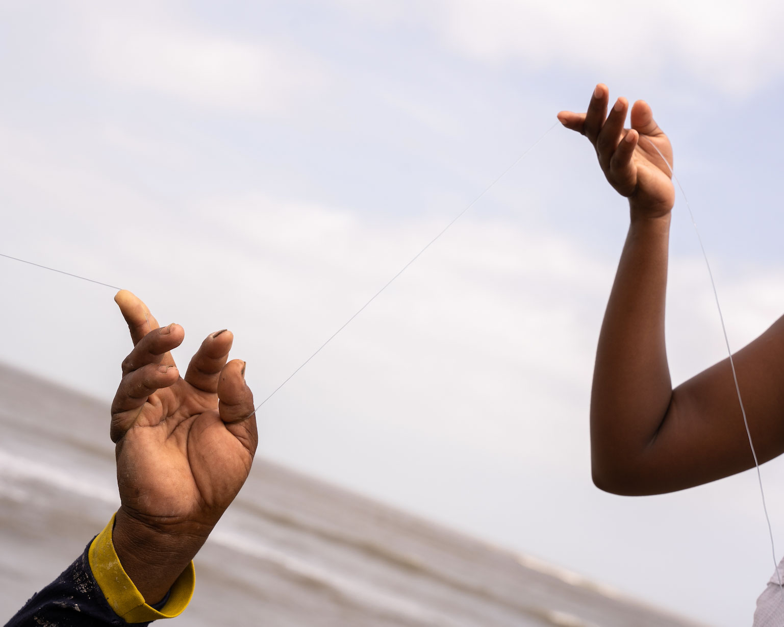 two hands holding a line of string