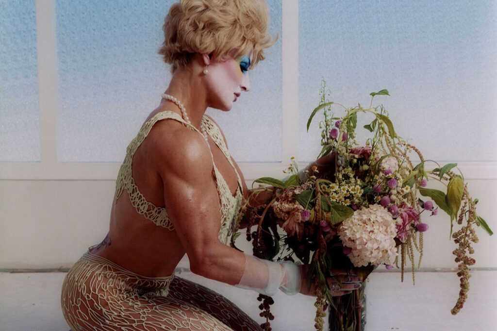 person sitting on knees holding flowers in a vase