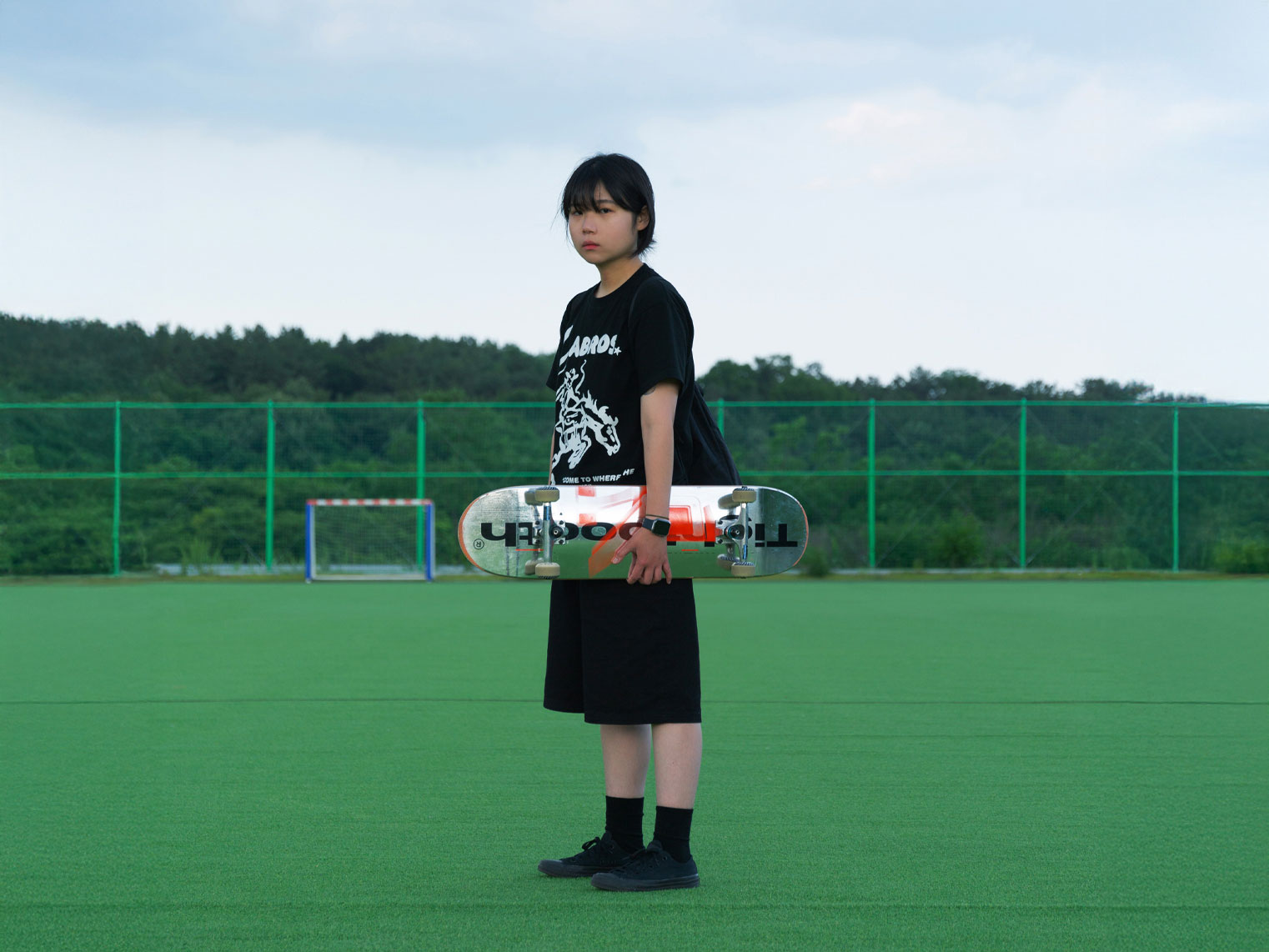 person on playing field holding silver skateboard