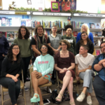 Group photo of transgender feminisms reading group members. Some people are standing, some are sitting, one is holding a cane.