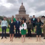 Author, Isaac James, standing outside the Texas Capitol with Rep. Mary González and office staff.