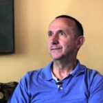 Bob Dailey, a person with short hair wearing a blue shirt looking away.