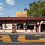 The Rolling Rooster restaurant during the day on a street corner. A sign in the window reads "STOP KILLING BLACK PEOPLE".