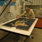 School of Information student Laura Bedford washes the poster on the vacuum-suction table.