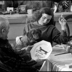 While Jacqueline Roque and Lump, David Douglas Duncan's dachshund, look on, Pablo Picasso inspects the souvenir luncheon plate he has just painted for and dedicated to Lump. La Californie, Cannes. Gelatin silver negative. April 19th, 1957. © David Douglas Duncan.