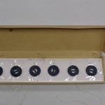 Box containing Mylar strips that hold the removed weights.
