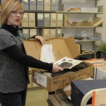 Ransom Center Archivist Amy Armstrong catalogs the Paul Schrader collection, locating a costume worn by Willem Dafoe in "Light Sleeper" (1992). Photo by Anthony Maddaloni.