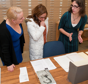 Helen Adair shows Maggie Cino and Faye Lane a notebook from Spalding Gray's archive. Photo by Pete Smith.