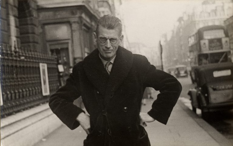 Photograph of Samuel Beckett taken by a street photographer outside Burlington House in Piccadily, ca. 1954.