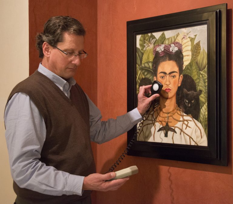 Ken Grant inspects lighting for Frida Kahlo’s “Self-portrait with Thorn Necklace and Hummingbird.” Photo by Pete Smith.