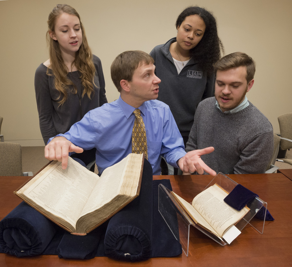 Elon Lang, seated in the center, and undergraduate students from "Drama in the Archives" view collection materials. Photo by Pete Smith.