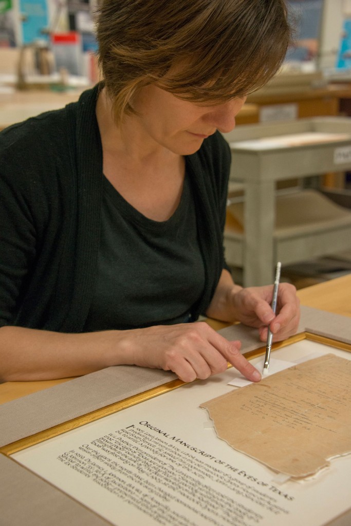 Conservator Heather Hamilton puts the finishing touches on the manuscript treatment. Photo by Pete Smith.