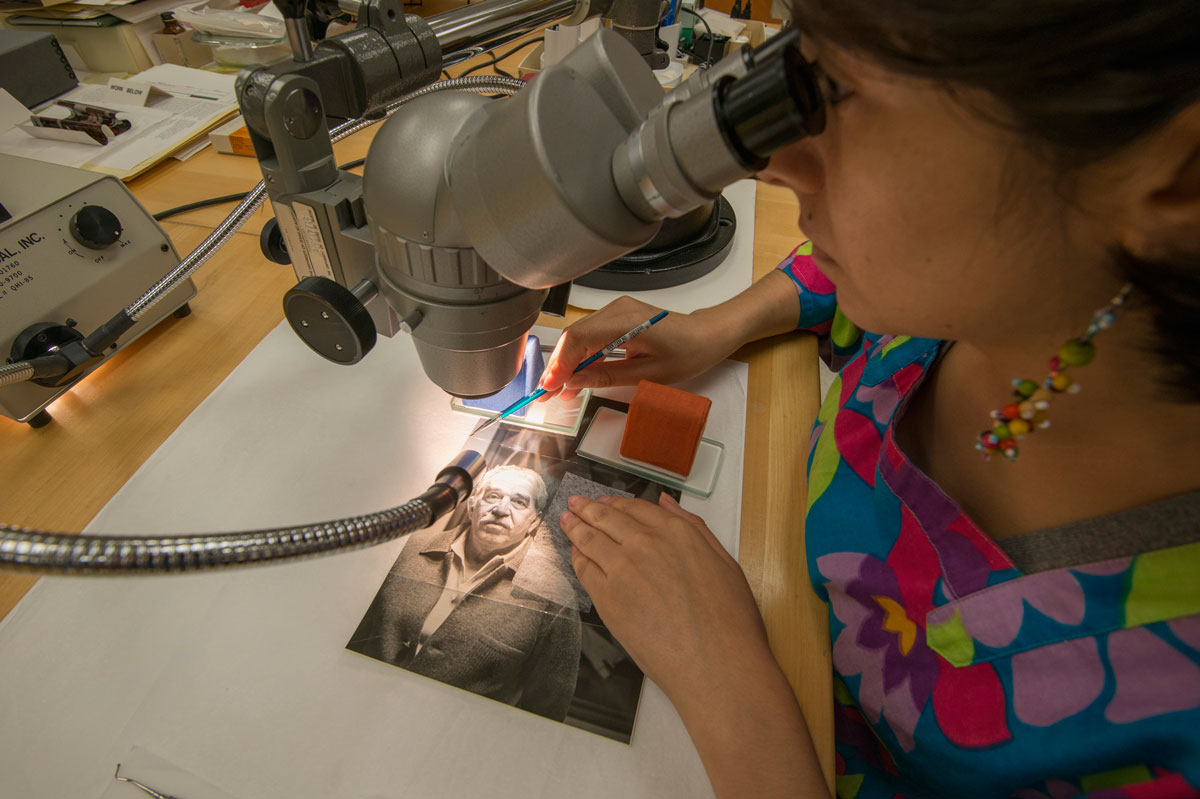 Conservator consolidating a crack in the gelatin emulsion layer of the photograph. Photo by Pete Smith. / Restauradora consolidando una grieta en la emulsión de gelatina de la fotografía. Fotografía por Pete Smith.