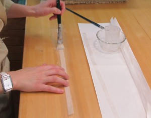 Pasting out a long fibered Japanese paper guard with Jin Shofu wheat starch to reconnect detached pages to the text block