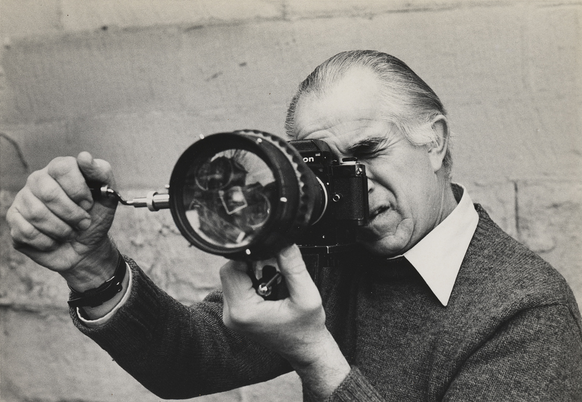 David Douglas Duncan looking through camera fitted with prismatic lens, between 1963 and 1972. Photo by Sheila Duncan