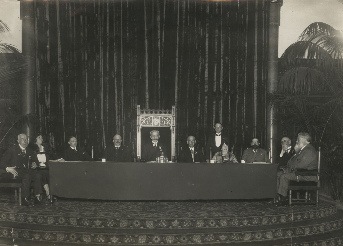 Unidentified photographer. Photograph taken at the PEN Congress in Holland, 1931; seated to the right of the podium are PEN president John Galsworthy and PEN founder Amy Catherine Dawson-Scott.