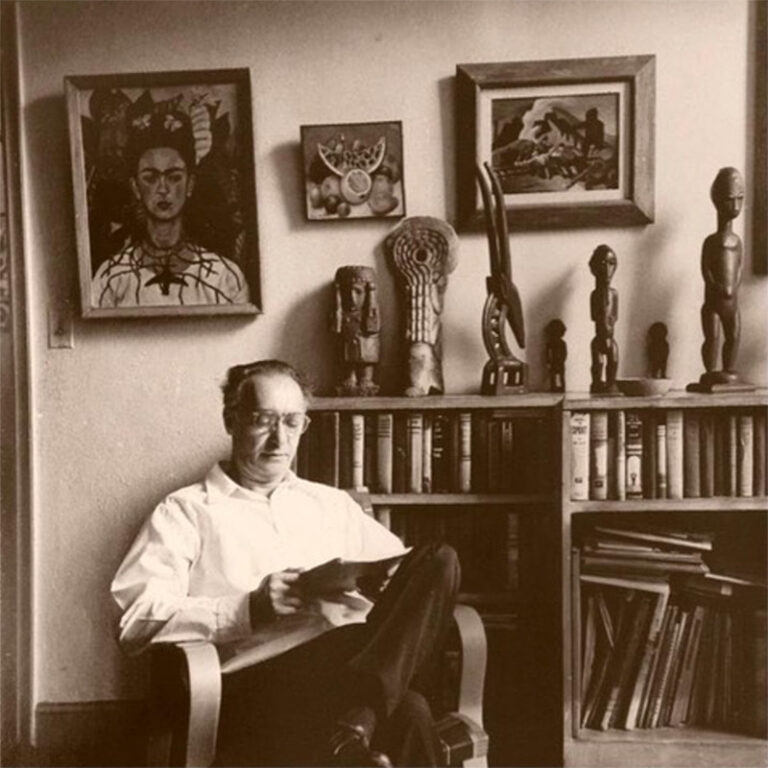 Nickolas Muray seated in front of Frida Kahlo's self portrait