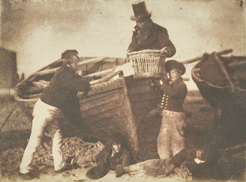 Two men and a boy posing next to a boat