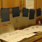 Colored sheets of Japanese paper dry that later will be used to fill in missing sections of the poster.