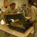 Bedford and Watkins brush out the poster onto the Japanese backing paper while the poster is attached to a sheet of Mylar.