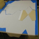 Card templates are used to guide the cloth cutting on a table protected with self-healing cutting mats. A rotary cutter with a zigzag blade was used to cut the cloth. Photo by Mary Baughman.