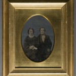 Seated Couple. Unidentified photographer. Oil on tintype. Ca. 1850s. Federal Revival style gilt frame.
