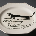 Souvenir luncheon plate painted by Pablo Picasso and dedicated to Lump, David Douglas Duncan's dachshund. Black glaze on commercial ceramic plate. 24 cm. in diameter. April 19th, 1957. Photo by Pete Smith. Image courtesy of Harry Ransom Center.