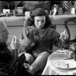 Pablo Picasso lights a cigarette while Jacqueline Roque and Lump, David Douglas Duncan's dachshund, study the freshly painted plate Picasso has just dedicated to Lump. La Californie, Cannes. Gelatin silver negative. April 19th, 1957. © David Douglas Duncan.