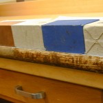 Inkyung applies a poultice of methylcellulose to the spine linings to soften the adhesive, in order to remove the linings using a micro spatula.