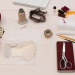 Varnell’s materials, including adhesive, threads, notebook, and the needle case made for her mother at age five. Photo by Pete Smith.