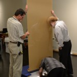 Exhibition Conservator and Head of Exhibition Services Ken Grant, Faulk, and Chief Preparator John Wright assemble the custom-designed pedestal.