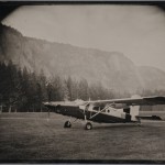 Robb Kendrick. "Untitled: ZX Ranch series," Montana, August 2009. "This image was made on a very remote ranch in Montana. The ranch is the ZX Ranch, a 200,000 acre ranch that spans Montana and Wyoming. The ranch owner David Leuschen's wife commissioned me to come to the ranch to make tintypes of their property as a birthday gift to her husband. They made a selection of 14 images and then purchased an additional 28 images. David had his pilot bring this Pilatus Porter aircraft into the ranch to be able to fly me into very remote areas. The plane is seen here on the grass strip on this part of the ranch in Montana. "David wanted an image made in a very remote location that my portable darkroom could not be taken. He suggested using the airplane as a taxi to and from the darkroom. From time of removal from the silver nitrate, making the exposure and returning to the darkroom times of 10 minutes is pushing the limits. We attempted making images on the remote section of the ranch where I flew to the location with the camera, set up the composition and had camera ready, flew back to retrieve a plate out of the silver nitrate fly to the camera location, make the exposure, fly back to the darkroom and process. Time roundtrip was 30 minutes. Flight time was 8.5 minutes each way. The images turned out. I'm sure I am the first tintype photographer to use an airplane to get to and from camera location."