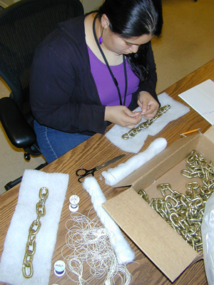 Samantha Cabrera constructing “book snakes” with chain links. Photo by Mary Baughman.