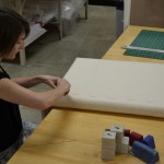 Head of Paper Conservation Heather Hamilton prepares the custom pad around which the map will be rolled. Photo by Pete Smith.