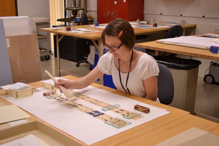 Head of Paper Conservation Heather Hamilton treats an animated Movie Jecktor scroll for the exhibition on “Alice in Wonderland.” Photo by Alicia Dietrich.