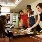 Teacher Andrea Gustavson shares photography materials with undergraduate students in her class "American Images: Photography, Literature, Archive" Photo by Robert V. Reichle.