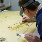 Ken Grant works in the paper lab, consolidating the paint layer on designer Norman Bel Geddes’s 1926 drawing for floats and participants in Macy’s Thanksgiving Day parade. Photo by Lee Tran.