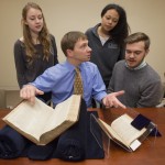 Elon Lang, seated in the center, and undergraduate students from "Drama in the Archives" view collection materials. Photo by Pete Smith.