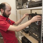 Eric Cartier, a graduate student in the School of Information, works with an audio reel of William Faulkner reading his own short story "The Bear." Photo by Pete Smith.