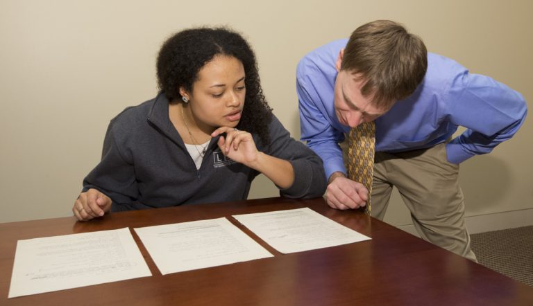 Haley Williams looks at archive materials with Professor Elon Lang. Photo by Pete Smith.