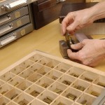 Setting brass type in a pallet to stamp a label for a book. Photo by Eric Beggs.