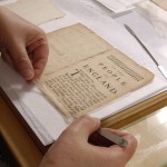 Mending a folio from "The Perfect Politician: Or, a Full View of The Life and Actions of Oliver Cromwel." Photo by Eric Beggs.