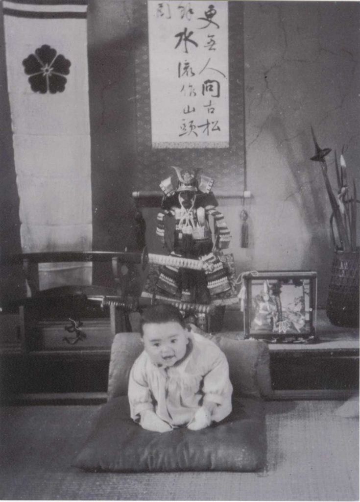 Unidentified photographer, [Kazuo Ishiguro as a baby in front of family samurai heirlooms, Nagasaki], ca. 1955. Gelatin silver print, 20.3 x 15 cm., Kazuo Ishiguro Papers, Harry Ransom Center.