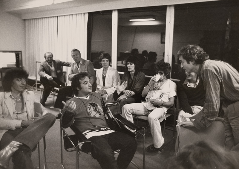 Nine seated men in a meeting