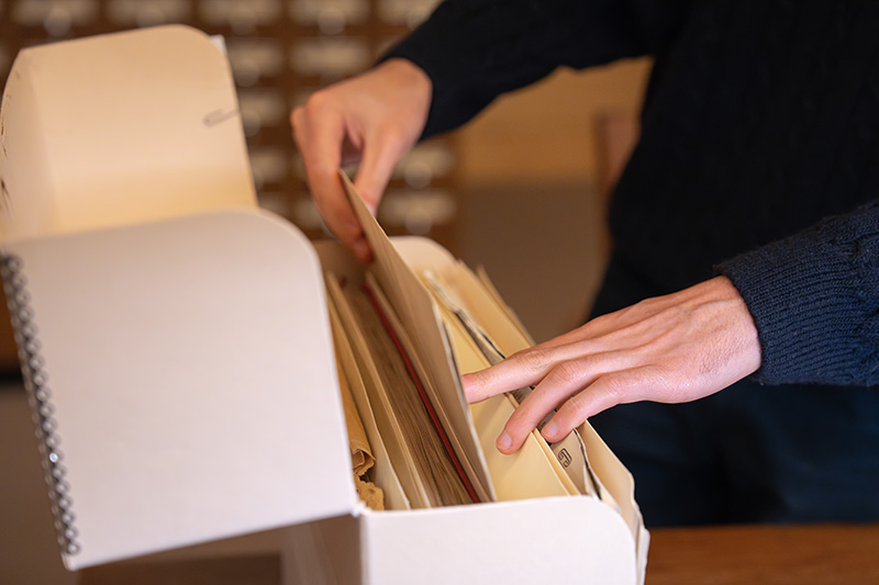Researcher looking through a box full of folders