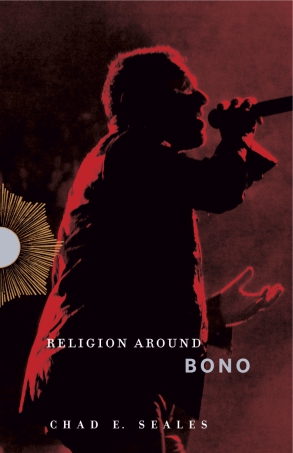 image of book cover of Religion Around Bono by Chad E. Seales, man holding a microphone with red spotlight