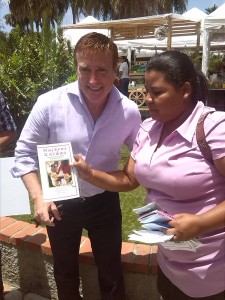 A member of Mujeres Unidas presents the US Ambassador with a brochure detailing the organization's work. 